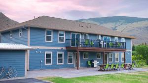 a blue house with a balcony and a table and chairs at Klippers Guest Suites in Cawston