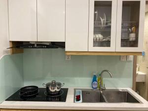 a kitchen with a sink and a stove top oven at Căn hộ dịch vụ Vinhome Smart in Phú Thú