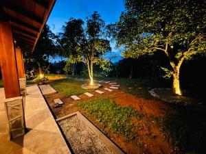 eine Nachtansicht eines Gartens mit zwei Bäumen in der Unterkunft Berg house mirissa in Mirissa