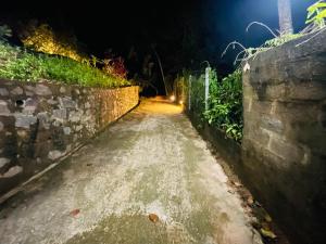 eine Straße bei Nacht mit einer Steinmauer in der Unterkunft Berg house mirissa in Mirissa