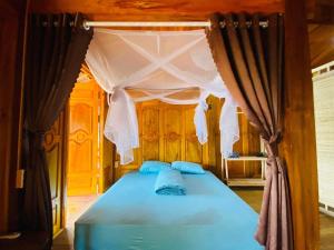 a bedroom with a blue bed with a canopy at Cao bành Homestay in Ha Giang