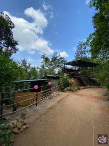 un bâtiment avec une clôture à côté d'un chemin de terre dans l'établissement Sri Craft Algama, à Warakapola 96 autres photos