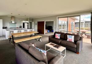 a living room with two couches and a table at Cedar Stars - Lake Tekapo in Lake Tekapo