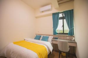 a bedroom with a bed and a desk and a window at 98Guesthouse in Jincheng +15 photos