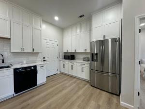 a kitchen with white cabinets and a stainless steel refrigerator at A Charming Villa in Vidalia GA - New Construction in Vidalia