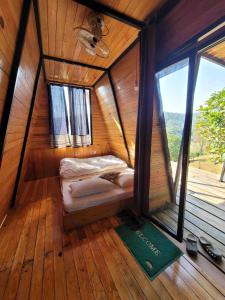 Habitación pequeña con cama en una casa de madera en Năm mùa Bungalows, en Hương Hóa