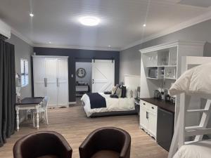 ein Schlafzimmer mit einem Bett und einem Schreibtisch und Stühlen in der Unterkunft The Homestead in Bloemfontein