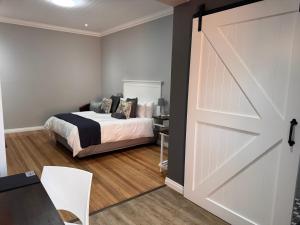 Schlafzimmer mit einem Bett und einer Schiebetür in der Unterkunft The Homestead in Bloemfontein + 58 Fotos