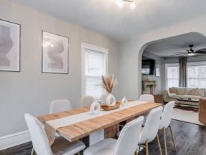 une salle à manger avec une table en bois et des chaises blanches dans l'établissement Upscale Home near Downtown Cle, R&R HoF, Beach, Arena, à Cleveland 20 autres photos
