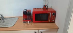 a red microwave sitting on top of a counter at Cock or Two Kink House in Cockatoo