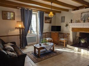 salon z kanapą i kominkiem w obiekcie Gîte familial avec jardin au bord de l'eau, terrasses, vélo, jeux, proche Charente, WiFi inclus - FR-1-653-189 w mieście Saint-Genis-dʼHiersac