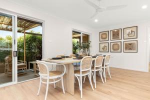 ein weißes Esszimmer mit Tisch und Stühlen in der Unterkunft Tide's Edge by Experience Jervis Bay in Vincentia