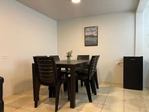 a dining room with a black table and chairs at Trendy apartment 2 bedroom 1 bath in Baños