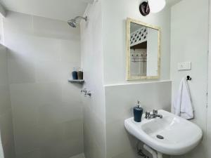 a white bathroom with a sink and a mirror at Trendy apartment 2 bedroom 1 bath in Baños