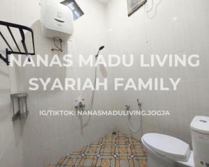 a bathroom with a toilet with the words namas madu living syari at Nanas Madu Living Syariah Family in Adi Sutjipto