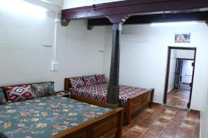 a room with a bed and a couch in a room at Lakshmi Home Stay, Kallidai in Tirunelveli