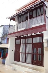 a building with two doors and a balcony at Lakshmi Home Stay, Kallidai in Tirunelveli