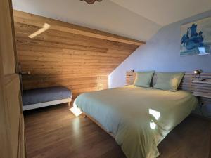 a bedroom with a large bed with a wooden wall at Appartement à la ferme vosgienne avec terrasse, cheminée et wifi - FR-1-589-759 in Fresse-sur-Moselle +12 photos