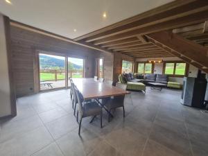 a dining room with a table and a living room at Chalet familial avec sauna et terrasse près du lac - FR-1-589-758 in Xonrupt-Longemer
