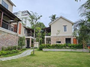 a house with a yard in front of a building at Sealight Villa and House Phu Quoc in Phu Quoc