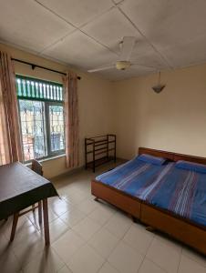 a bedroom with a bed and a table and a window at Seven Star Guest Inn in Passara