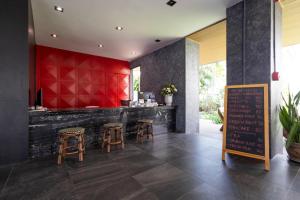 a bar with stools and a red wall at Penpark Place in Bangkok