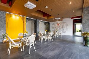 a restaurant with white chairs and tables and a yellow wall at Penpark Place in Bangkok