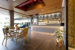 a restaurant with a table and chairs and a bar at Penpark Place in Bangkok