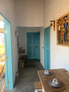 ein Esszimmer mit einem Tisch und einer blauen Tür in der Unterkunft Cajumar in Cajueiro