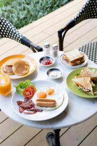 a table with plates of breakfast foods on it at Penpark Place in Bangkok