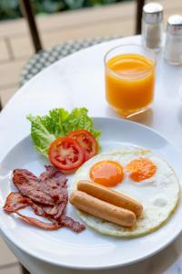 a plate of breakfast food with a hot dog and bacon at Penpark Place in Bangkok
