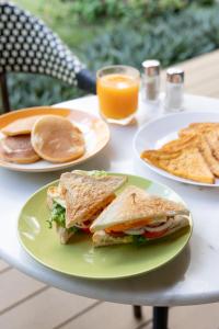 a table with two plates of food and a sandwich and chips at Penpark Place in Bangkok