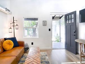 a living room with a brown couch and a door at Unique Denver Tiny House Skiing, Shopping, Hiking in Englewood