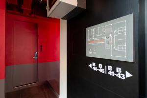 a red door in a room with a sign on the wall at Penpark Place in Bangkok