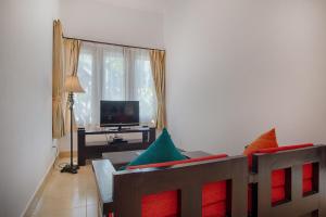 a living room with a couch with colorful pillows at The Tukad Villa in Seminyak