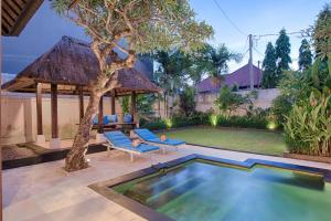 a backyard with a swimming pool and a gazebo at The Tukad Villa in Seminyak