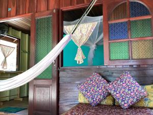 Cette chambre comprend un lit avec des oreillers et un hamac. dans l'établissement Sawasdee Resort, à Koh Chang Ranong