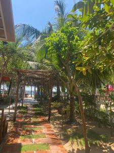 un sentiero alberato e una struttura in legno sulla spiaggia di Villa Hoàng Diệu Phú Quý 260m2 có bãi tắm trước nhà a Cù Lao Thu