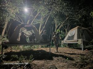 Ko Khang TakPhaluayCamping的一群人晚上站在帐篷周围