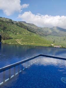 a pool of water with a view of a mountain at Silver cascade in Devikolam