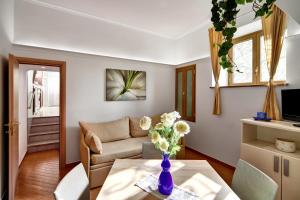 sala de estar con sofá y mesa con un jarrón de flores en Casa dellAccademia Apartment in Sorrento Centre, en Sorrento