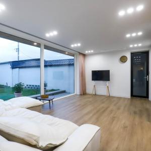 un soggiorno con mobili bianchi e una grande finestra di Damonga a Damyang