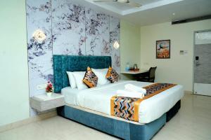 a bedroom with a king sized bed with a blue headboard at The Orange Hotel in Visakhapatnam