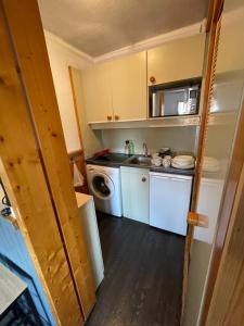 a small kitchen with a sink and a washing machine at Appartement de montagne in Prémanon +6 photos
