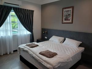 a bedroom with a bed with two towels on it at Garden inn in Ipoh