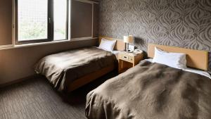 una camera d'albergo con due letti e una finestra di Okazaki Daiichi Hotel a Okazaki