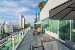 曼谷MUU Bangkok, Small Luxury Hotels of the World的设有带桌椅的市景阳台。