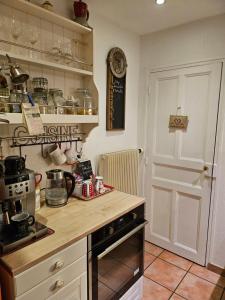 una cucina con piano di lavoro e piano cottura forno superiore di Le Clos du Moulin Dijon,sa piscine, son jardin, au calme, la campagne à la ville a Digione