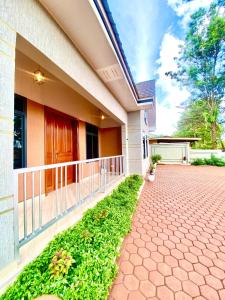 a house with a porch and a driveway at Clisa Rest House in Karatu