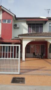 uma casa com um portão branco e um pátio em 30 Guest House em Malaca